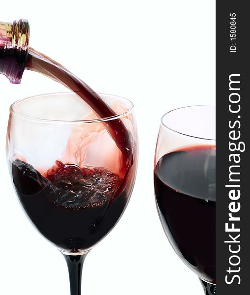 Two wineglasses filling with red wine isolated on white. Two wineglasses filling with red wine isolated on white