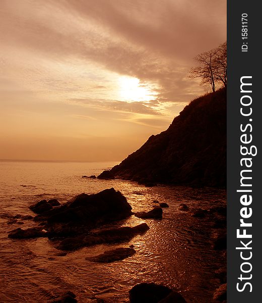 Sea shore, sunset, cliff, sea, rocks, sky, clouds, sun, red. Sea shore, sunset, cliff, sea, rocks, sky, clouds, sun, red