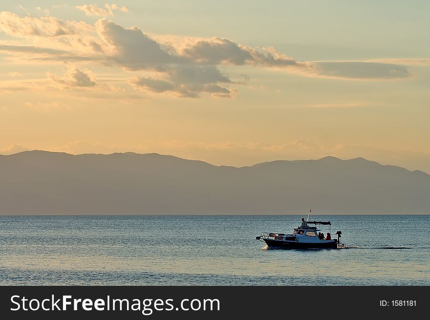 Moving boat on sea at sunset