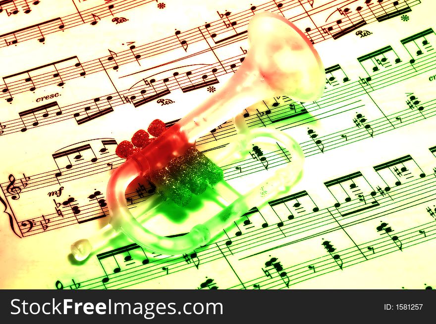 Photo of a Trumpet Ornament on SHeetmusic - Christmas Carol. Photo of a Trumpet Ornament on SHeetmusic - Christmas Carol