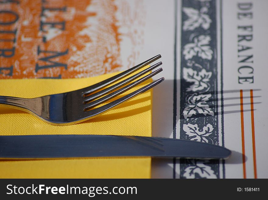 A knife and fork in a French restaurant, good for signifying travel or for a restaurant brochure / advertisement. A knife and fork in a French restaurant, good for signifying travel or for a restaurant brochure / advertisement