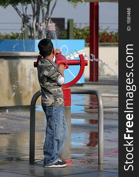 Boy shooting water gun at amusement park. Boy shooting water gun at amusement park