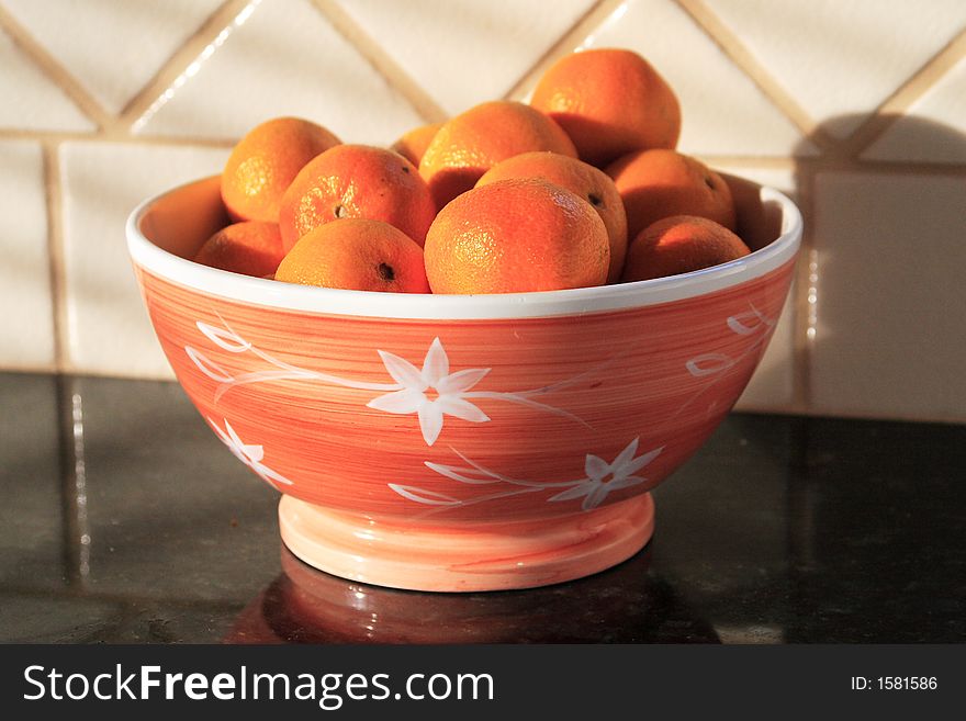 Oranges in bowl in morning sun. Oranges in bowl in morning sun