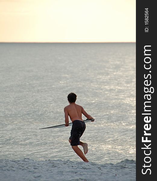 Surfing by sunset on a white sand beach in Florida. Surfing by sunset on a white sand beach in Florida