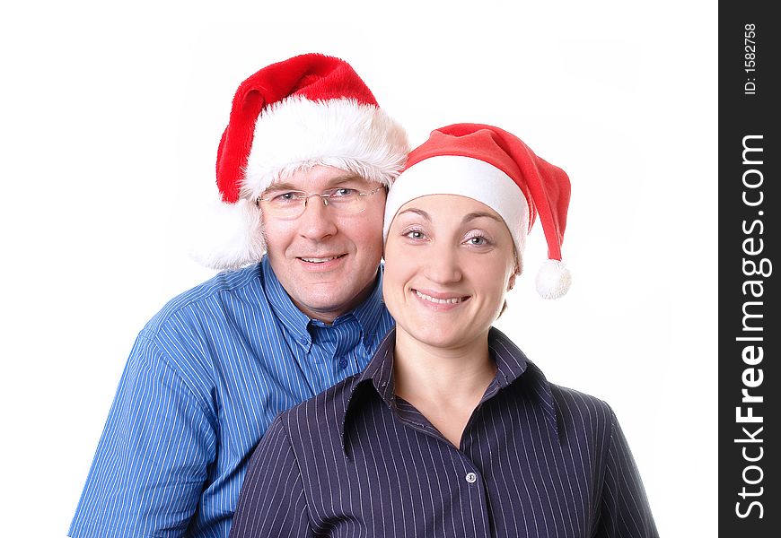 Portrait of young happy couple wearing red santa hats over white background. Portrait of young happy couple wearing red santa hats over white background