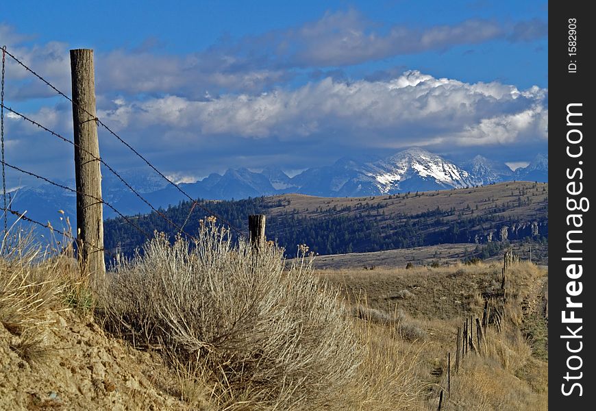 This image of the fence, hills and snowcapped mountains in the background was taken in the Mission Valley of western MT. This image of the fence, hills and snowcapped mountains in the background was taken in the Mission Valley of western MT.