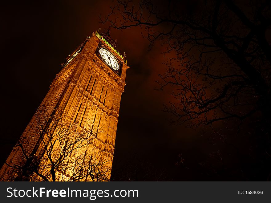 The famous Big Ben in London glows against heavy clouds. The famous Big Ben in London glows against heavy clouds.