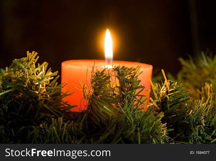 Red candle burning on black background