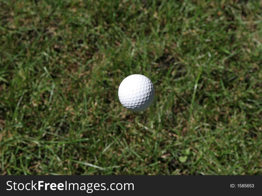 Golf ball mid flight suspended in mid air