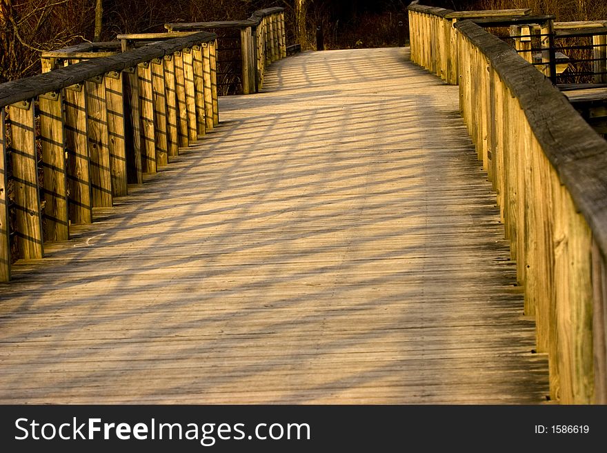 A boardwalk with handrails and intriguing shadows. A boardwalk with handrails and intriguing shadows