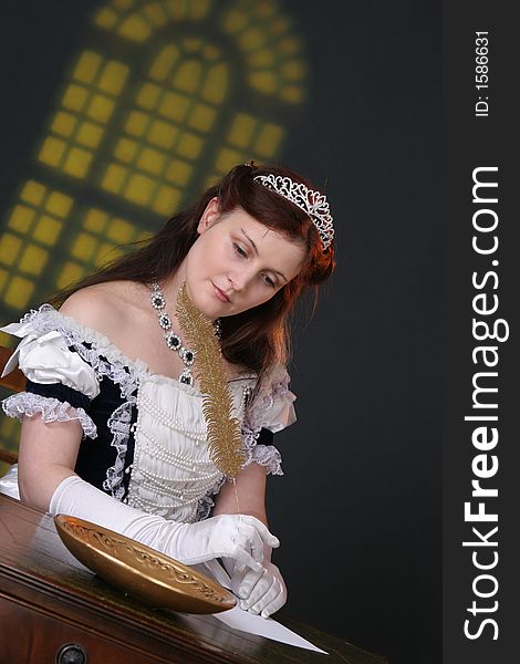 Girl in historic robe writing a letter