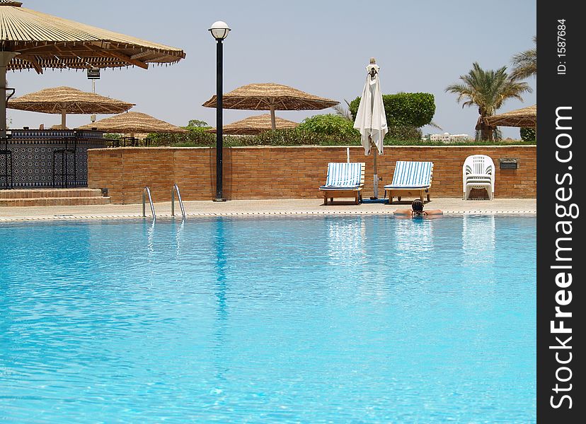 Girl floating in an almost empty swimming pool