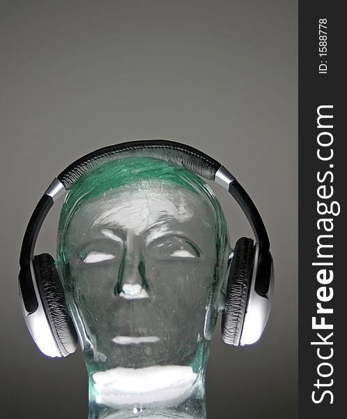 Front view of headphones on glass head. Front view of headphones on glass head