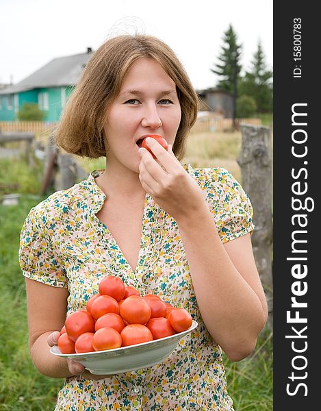 Attractive farmer is tasting harvest of tomatoes