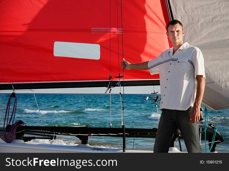 Young man on sea catamaran background