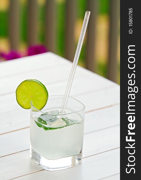 Glass of lime juice on white wooden table