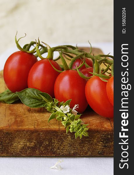 Fresh cherry tomatoes and fresh basil on wooden tray