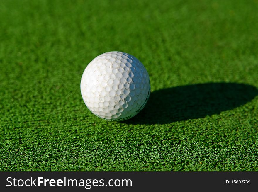 White golf ball lying on a grass