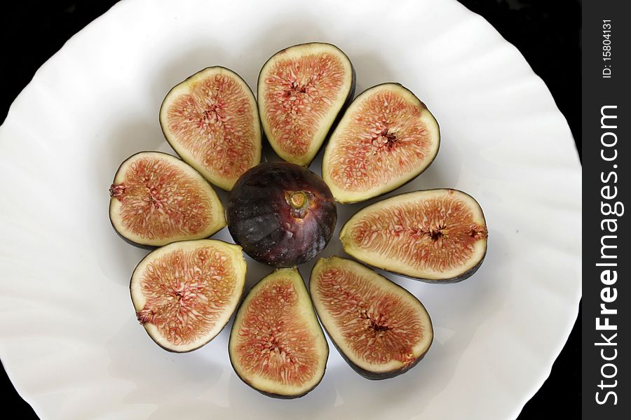 Ripe sliced figs on the plate in isolated over black