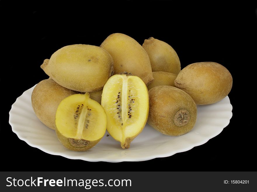 Yellow kiwi whole and slice from New Zealand in isolated over black