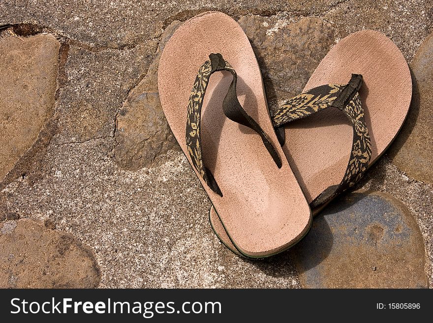 Sandals on a rocky walkway.