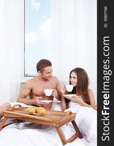 Young couple at breakfast in the bedroom. Young couple at breakfast in the bedroom
