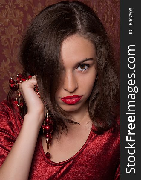 A beautiful girl with red lips is holding the beads in their hands. A beautiful girl with red lips is holding the beads in their hands.