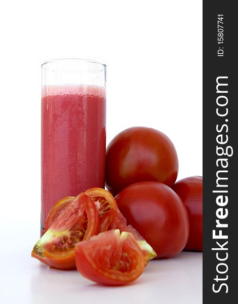 Fresh tomatoes and a glass full of tomato juice isolated on a white background. Fresh tomatoes and a glass full of tomato juice isolated on a white background