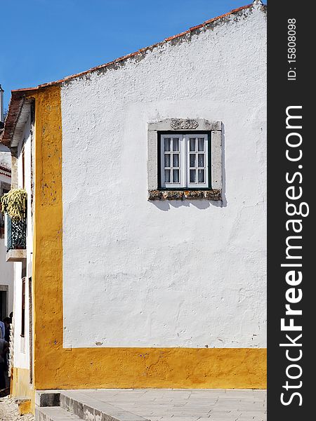 Old european house with white wall and window in sunny day(Obidos, Portugal). Old european house with white wall and window in sunny day(Obidos, Portugal)
