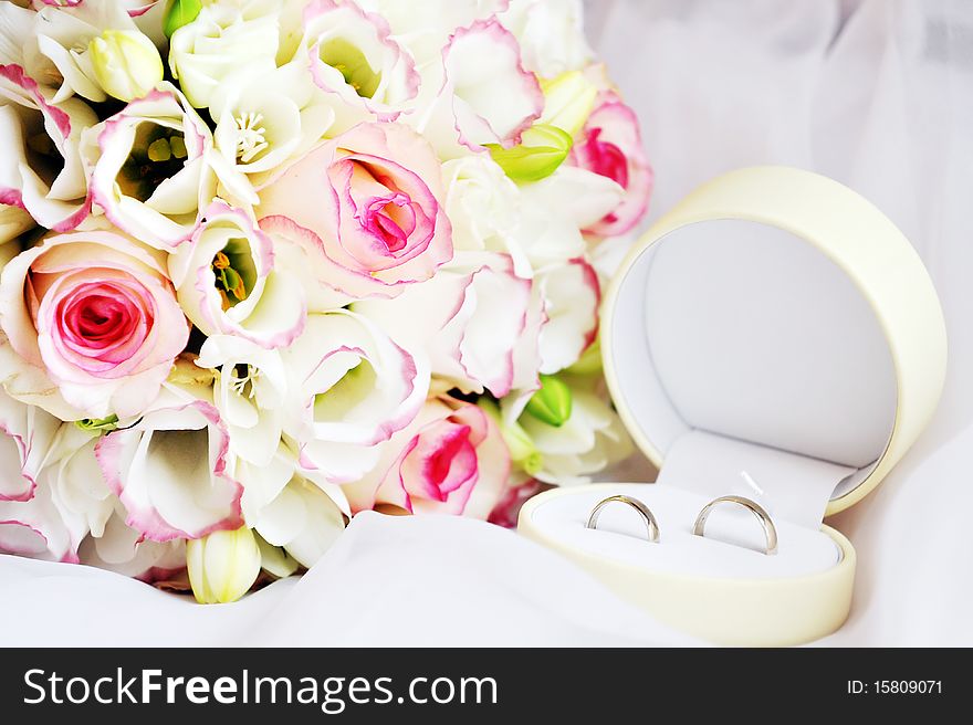 Wedding rings and bouquet of roses