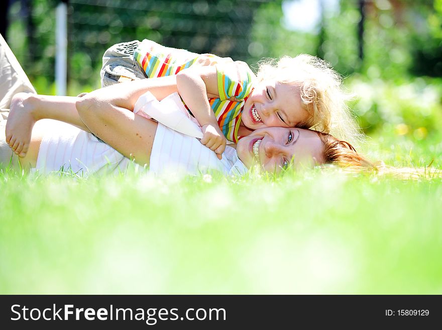 Beautiful young mother with her  daughter playing on grass . summer. Beautiful young mother with her  daughter playing on grass . summer.