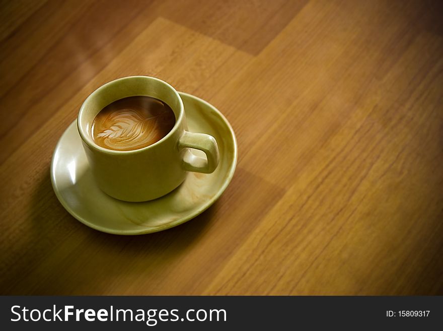 Coffee (cappuccino) with Little Art over wooden shaded background. Coffee (cappuccino) with Little Art over wooden shaded background