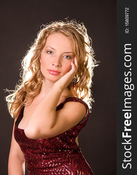 A portrait of beautiful young woman is singers of opera theater in a studio, dressed in a red dress. A portrait of beautiful young woman is singers of opera theater in a studio, dressed in a red dress