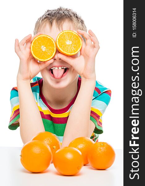 Vertical portrait of a funny boy with oranges on a white