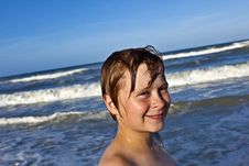 Young Boy Enjoys The Waves Of The Blue Sea Stock Photography