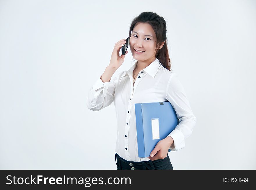 A Beautiful Asian business woman is on the cell phone,who was carrying a folder