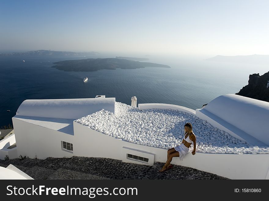 Woman in white with santorini view in the background