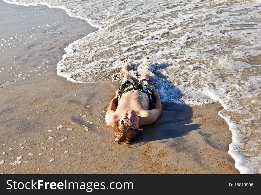 Boy Lying At The Beach And Enjoying The Sun