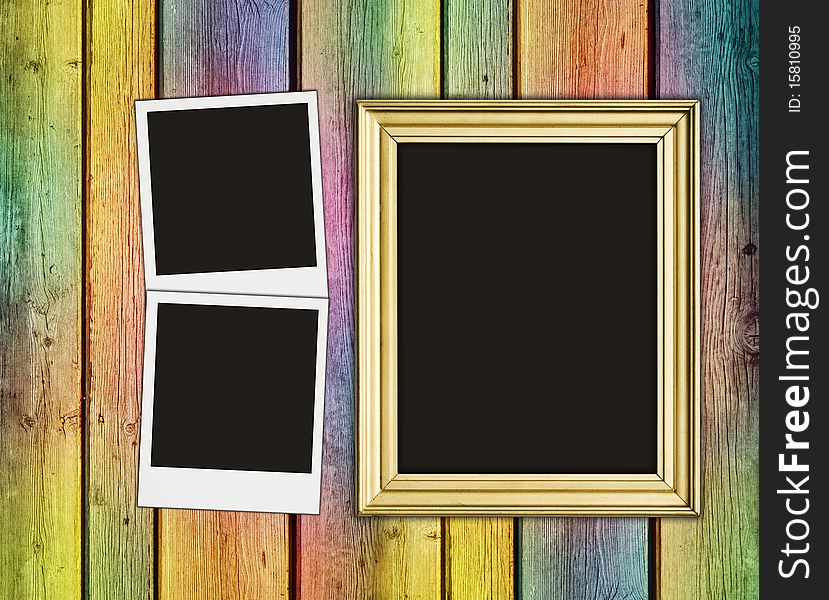 Blank photos and frame on vintage multicolored wooden background