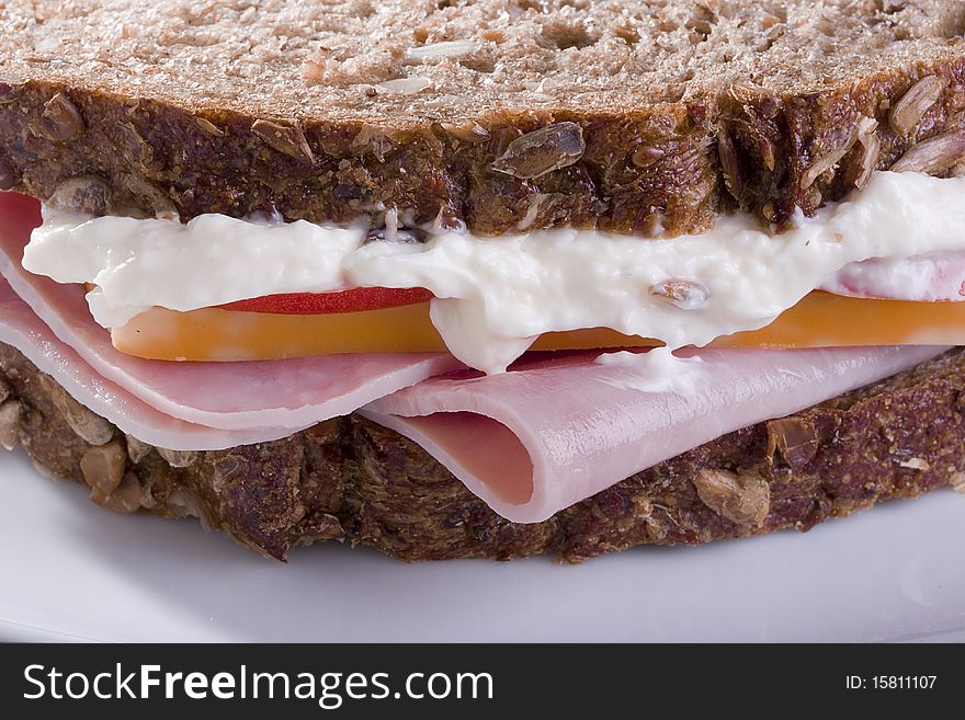 Close-up of a sandwich with turkey, cheese, and mayo.