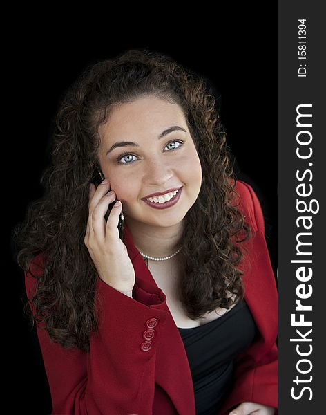 An attractive young business woman talking on cell phone, black background. An attractive young business woman talking on cell phone, black background
