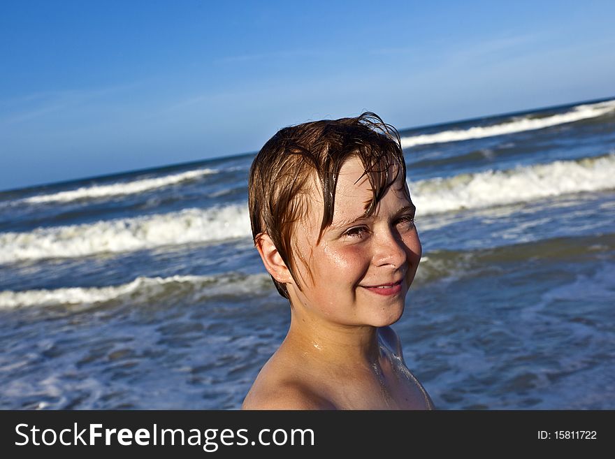 Young Boy Enjoys The Waves Of The Blue Sea