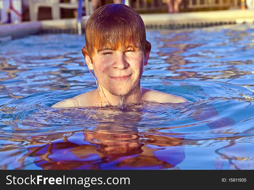 Young child with red hair has fun in the outdoor pool. Young child with red hair has fun in the outdoor pool