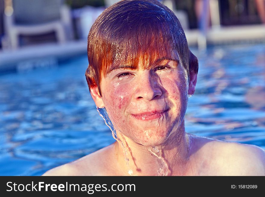 Child with red hair has fun in the outdoor pool. Child with red hair has fun in the outdoor pool