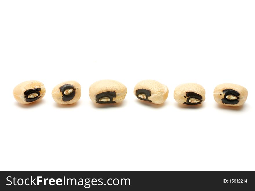 6 black eye beans seeds are laid in a horizontal row. Isolated on white background. 6 black eye beans seeds are laid in a horizontal row. Isolated on white background.