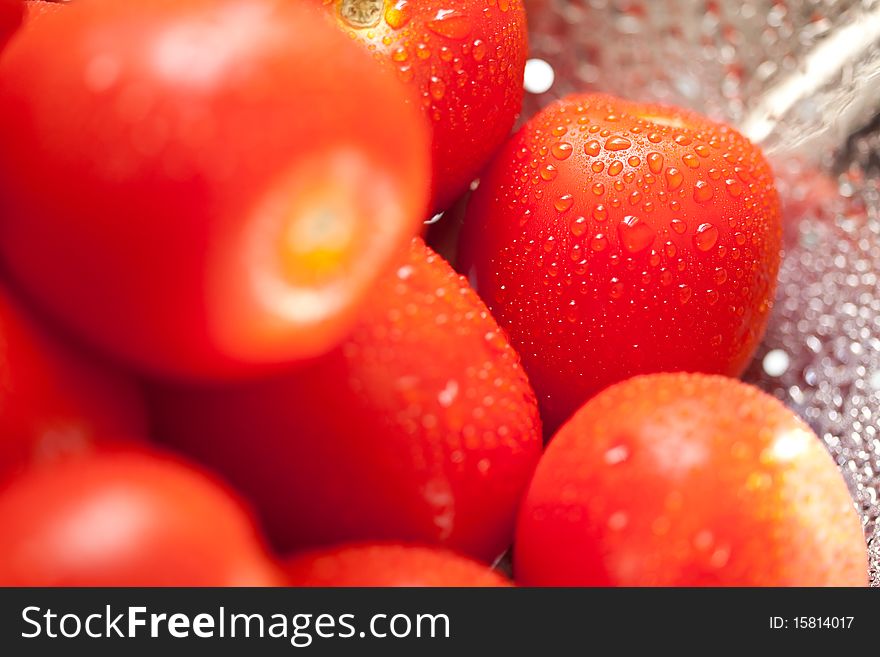 Vibrant Roma Tomatoes in Colander with Water Drops