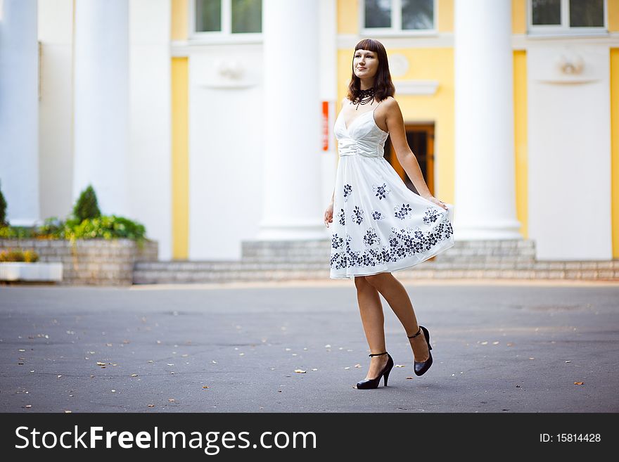 Young beautiful girl stands in front of house