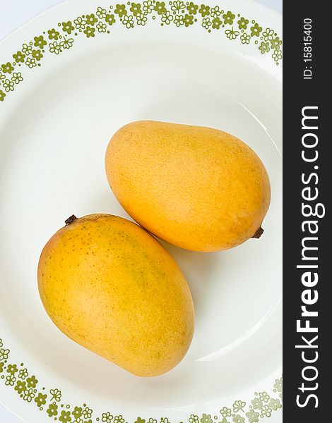 Ripe golden mangoes on white dish