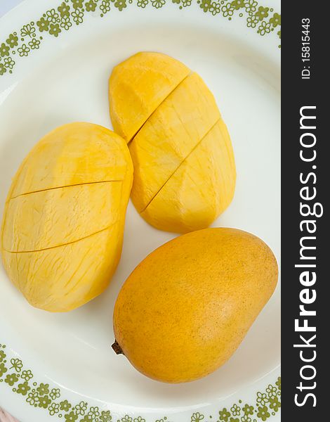 Ripe golden mangoes on white dish