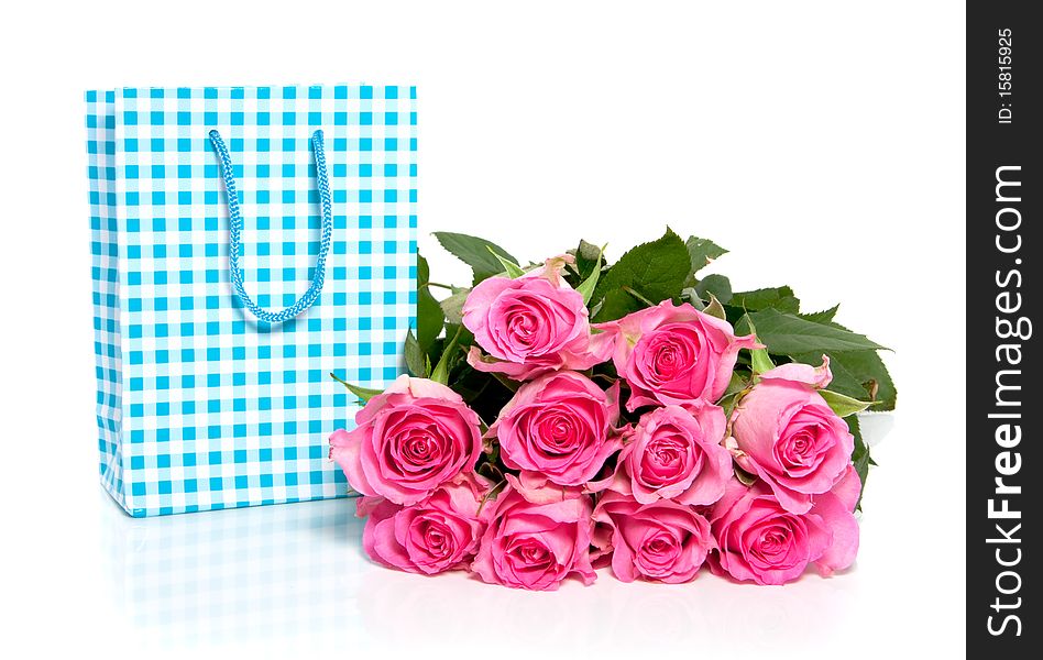 A bunch of pink roses with a blue checkered giftback isolated over white